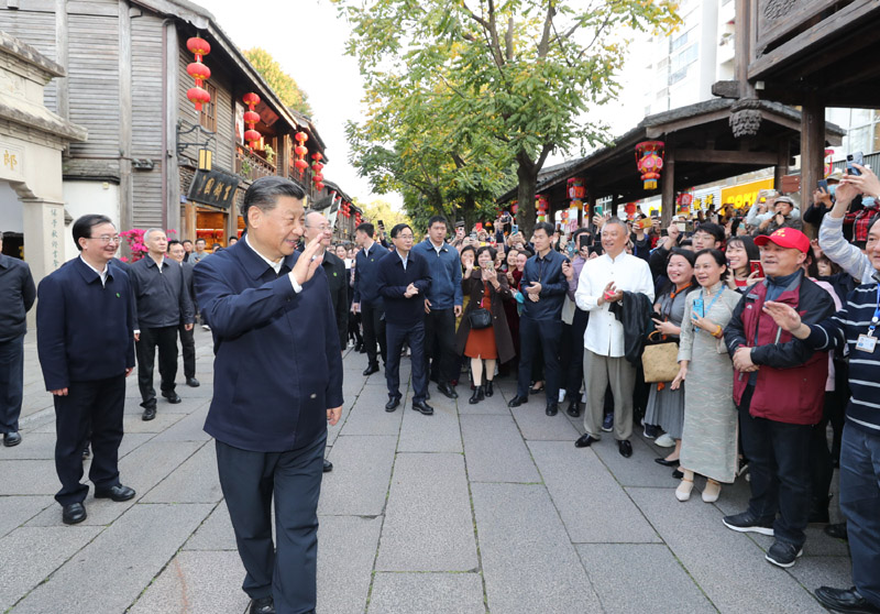 3月22日至25日，中共中央總書記、國家主席、中央軍委主席習(xí)近平在福建考察。這是24日下午，習(xí)近平在福州三坊七巷歷史文化街區(qū)考察時，向游客和市民招手致意。新華社記者 鞠鵬 攝